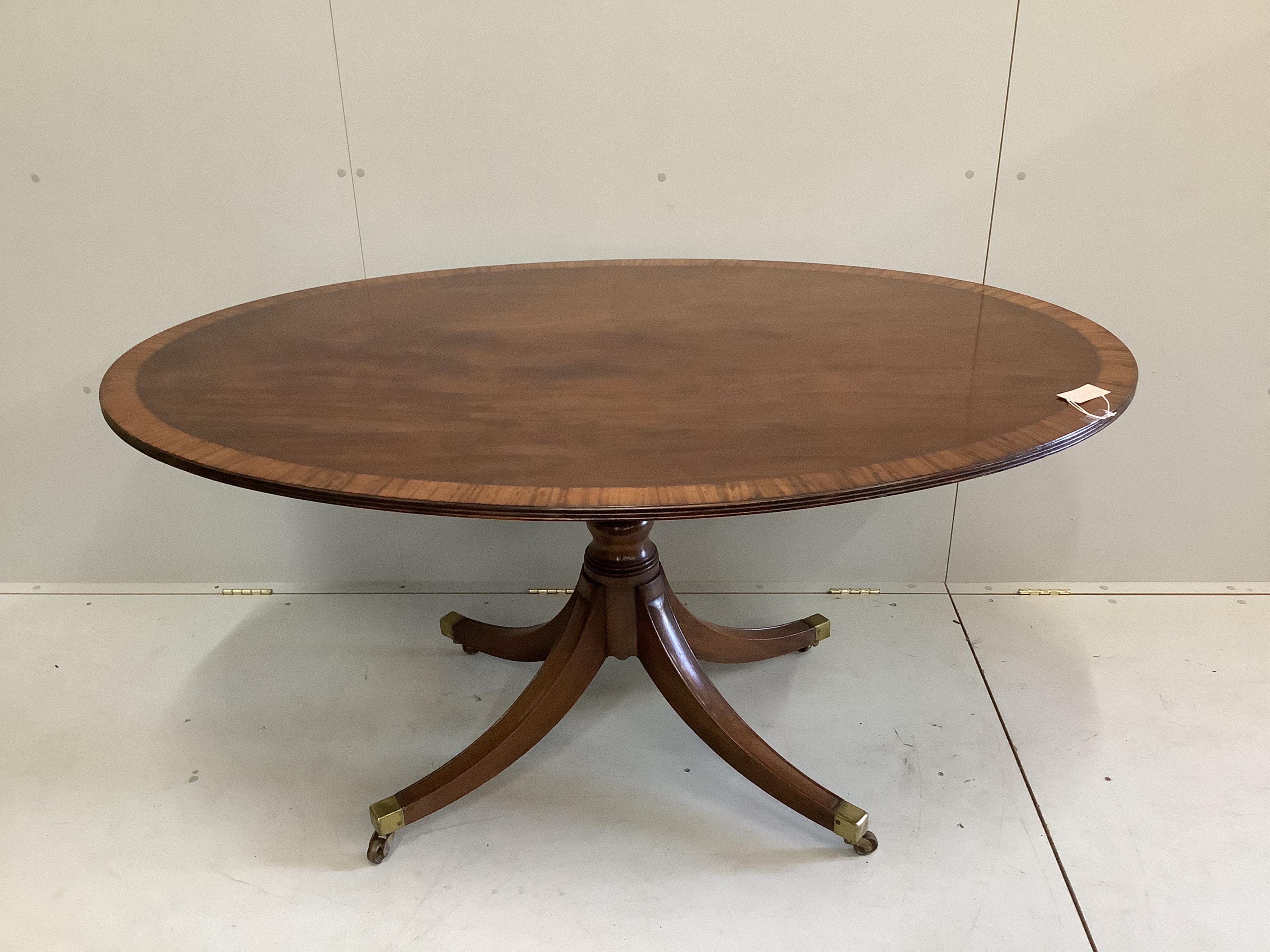 A George III and later satinwood banded oval mahogany tilt top dining table, width 152cm, depth 103cm, height 75cm